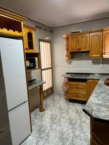 a kitchen with wooden cabinets and a white refrigerator at Apartamento Mágina in Mancha Real