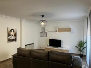 a living room with a couch and a flat screen tv at Apartamento Mágina in Mancha Real