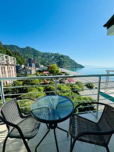 a table and chairs on a balcony with a view of the ocean at Black Sea Hotel in Kvariati