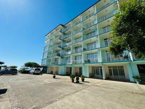 un grande condominio con auto parcheggiate in un parcheggio di Black Sea Hotel a Kvariati