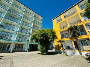 un edificio giallo con un albero di fronte di Black Sea Hotel a Kvariati