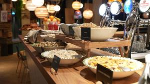a buffet with bowls of food on a table at Villa Viva - ein Haus das Brunnen baut in Hamburg