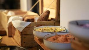 a table with bowls of food and a box of bread at Villa Viva - ein Haus das Brunnen baut in Hamburg
