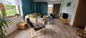 a living room with a couch and a tv at Bei Mallok's in Drebach
