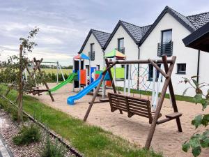 a playground with a bench and a slide at Piaski Morza A in Gąski