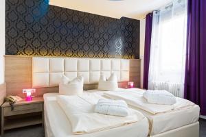2 Betten in einem Hotelzimmer mit weißen Kissen in der Unterkunft Bavaria Hotel Münchner Hof Superior in Stuttgart