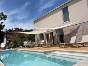 a house with a swimming pool with chairs and a patio at VILLA RITA ARTaTORE in Mali Lošinj