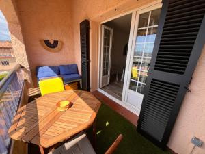 a balcony with a wooden table and chairs on a patio at Six fours les lones T2 42m2 vue mer in Six-Fours-les-Plages