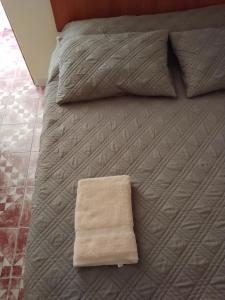 a bed with a blanket and a towel on it at APARTHOTEL Santa Maria in Punta de Choros
