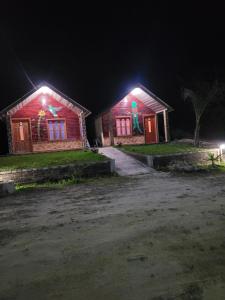 two wooden buildings with lights on them at night at Cabañas la frontera tziscao in La Trinitaria