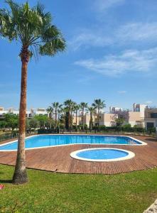 a large swimming pool with a palm tree next to it at Urbanización Panorámica Golf in Sant Jordi