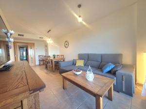 a living room with a blue couch and a table at Urbanización Panorámica Golf in Sant Jordi