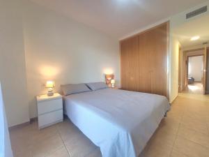 a bedroom with a white bed and a wooden cabinet at Urbanización Panorámica Golf in Sant Jordi +18 photos