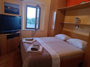 a bedroom with a bed and a tv and a window at Nonna Kate in Komin