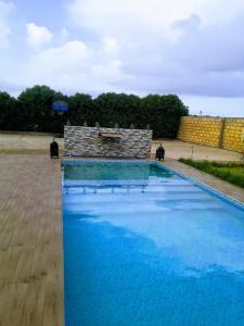 a swimming pool with blue water in front of a building at Landelijke Villa Azzemour in Douar Bouidat