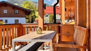 a wooden deck with a wooden bench and a table at La Montana Ski & Hiking LODGE in Schladming