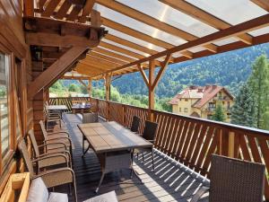 a wooden deck with a table and chairs on it at Tęczowe Wzgórze in Szczawnica