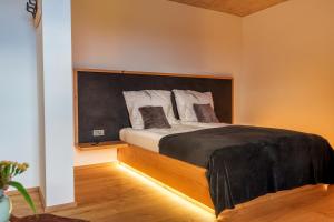 a bedroom with a bed with a large headboard at Hotel Frost in Maribor