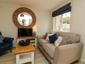 ein Wohnzimmer mit einer Couch und einem Spiegel in der Unterkunft Martin Cottage in Berrynarbor