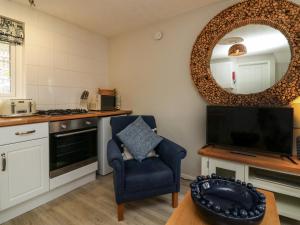 ein Wohnzimmer mit einem Stuhl und einem Spiegel in der Unterkunft Martin Cottage in Berrynarbor + 12 Fotos