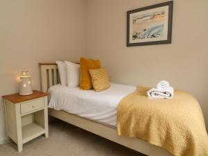 ein kleines Schlafzimmer mit einem Bett und einem Nachttisch in der Unterkunft Martin Cottage in Berrynarbor