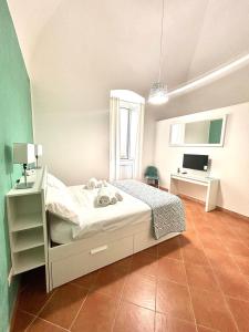 a bedroom with a white bed and a desk at BeB all'Ombra del Castello in Trani +2 photos