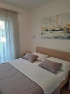 a bedroom with a large bed with a painting on the wall at Smokvica - NEW in Primošten