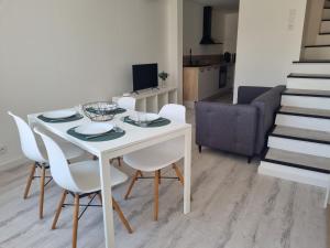 a dining room with a white table and white chairs at Maison de village avec terrasse in Grans +1 photo