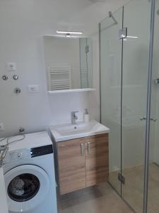 a bathroom with a washing machine and a sink at Smokvica - NEW in Primošten +38 photos