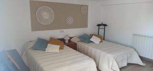 2 Betten in einem Zimmer mit weißen Wänden und blauen Kissen in der Unterkunft La Casa de Mendaza UAT01610 in Mendaza