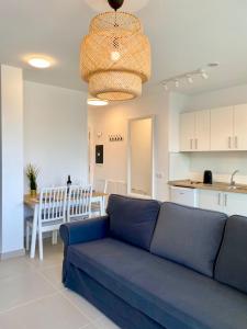 a living room with a blue couch and a kitchen at Mulata Doré Suite in Corralejo