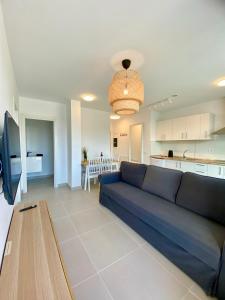 a living room with a blue couch and a kitchen at Mulata Doré Suite in Corralejo