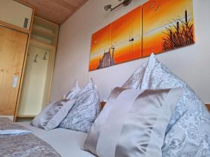 a bedroom with a bed with pillows on it at Appartements Regina in Mörbisch am See