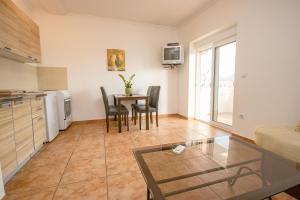 a kitchen and dining room with a table and chairs at Sea Whisper Apartment in Budva