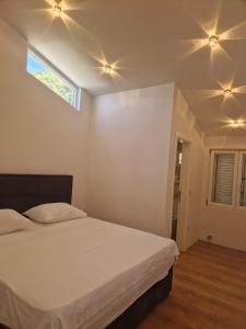 a bedroom with a white bed and a window at Apartman SIX in Brela