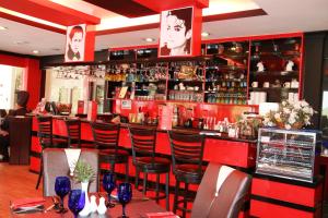 a bar in a restaurant with red walls and stools at EDC UUM Sintok in Sintuk