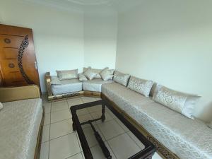 a living room with a couch in a room at Appartement Spacieux et Accueillant avec Vue Panoramique sur la Mer in Martil