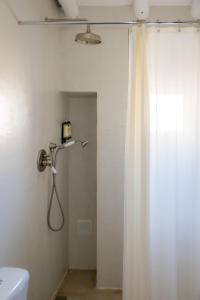 a white shower curtain in a bathroom with a toilet at Casas Velhas - Casa da Taberna in Castro Verde