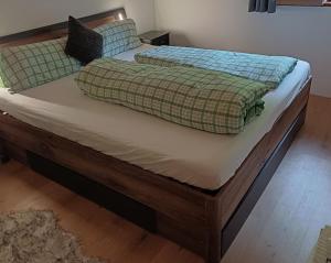 sypialnia z łóżkiem z drewnianą ramą w obiekcie BERGCHALET VALLUGA w mieście Steeg