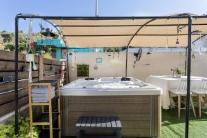 a hot tub in a backyard with a table and chairs at שלווה בגלבוע - וילה מדהימה עם ממ"ד ג'קוזי ובריכה בגדעונה in Gid‘ona