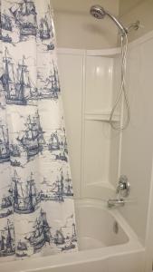 a bathroom with a shower curtain with boats on it at North Rustico Harbour Inn in North Rustico