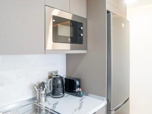 A kitchen or kitchenette at Newly renovated, luxurious apartment with a heated pool, 259
