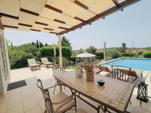 a patio with a table and chairs and a pool at Villa Sun in Čilipi