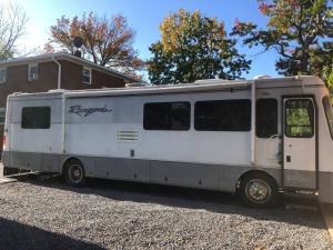un remolque blanco estacionado frente a una casa en Private 1-bedroom RV with full hookups and direct bus to NYC Manhattan only 2 blocks away, en Linden