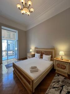 une chambre avec un grand lit et un lustre dans l'établissement White Boutique Nizami Hotel, à Baku