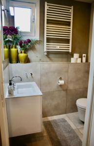 a bathroom with a sink and a window and flowers at Casa del Queso in Alkmaar