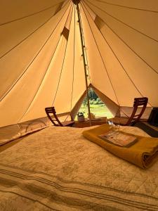 a bed with two chairs and a large tent at Rondane Friluftssenter Rondetunet in Brenn +37 photos