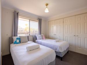 a bedroom with two beds and a window at 4 Beds Family House at Sunnybank Hills in Brisbane