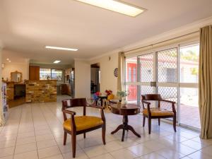 a living room with a table and chairs at 4 Beds Family House at Sunnybank Hills in Brisbane