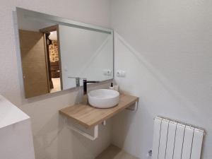 a bathroom with a white sink and a mirror at La casita de Mena in Hoz de Mena